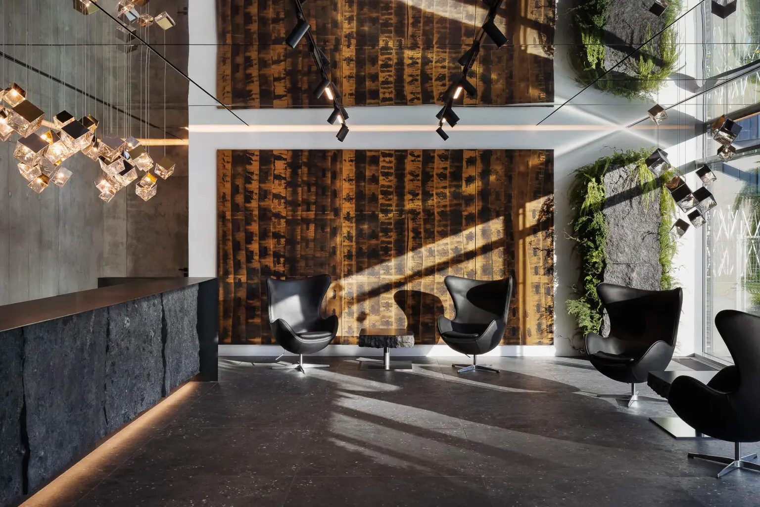 Designový moderní interiér lobby s černými křesly a abstraktním uměním.