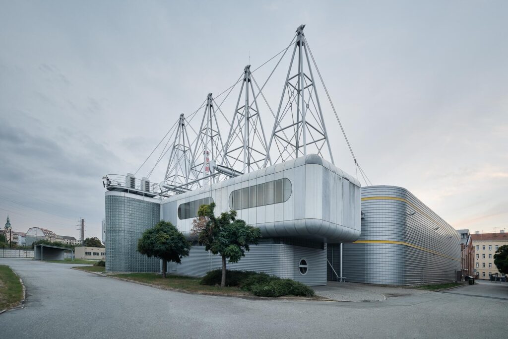 Moderní budova s futuristickým designem, kovovým opláštěním.