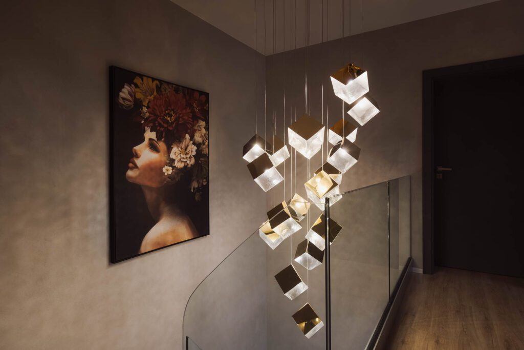 Moderní designové osvětlení chodby s obrazem na stěně.