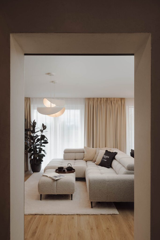 Průhled do moderního interiéru luxusního obývacího pokoje s béžovým gaučem.