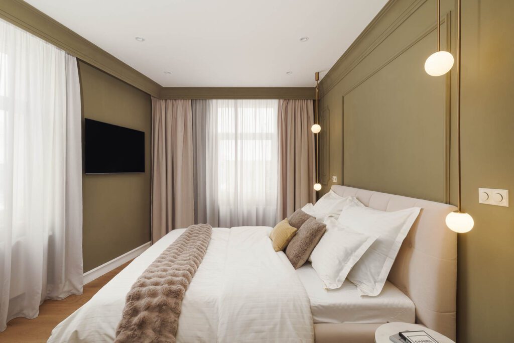 Moderní elegantní ložnice s několika polštáři.